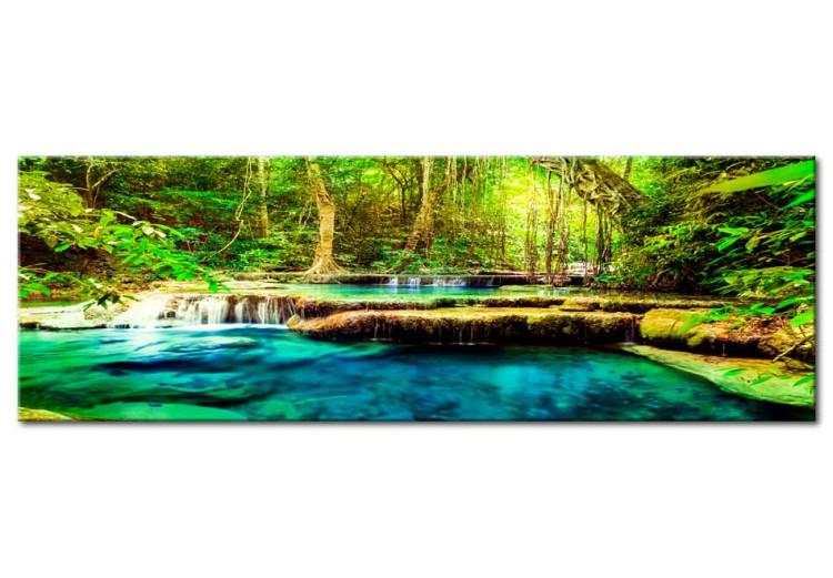Canvas Print Small waterfalls - a river with blue water among green vegetation