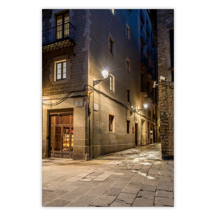 Poster Charming Alley - illuminated architecture of stone buildings at night