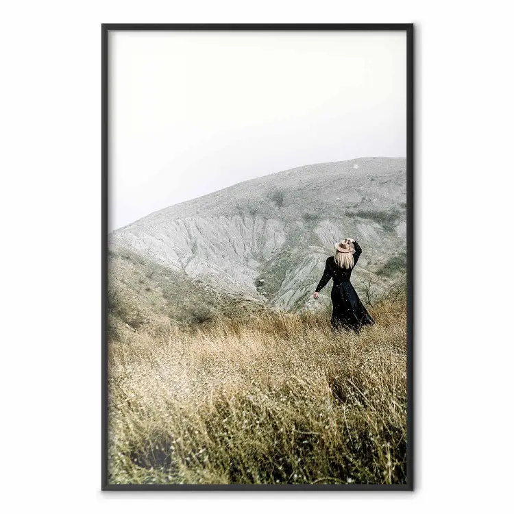 Lost in Nature - landscape of a meadow with a woman against a mountain range