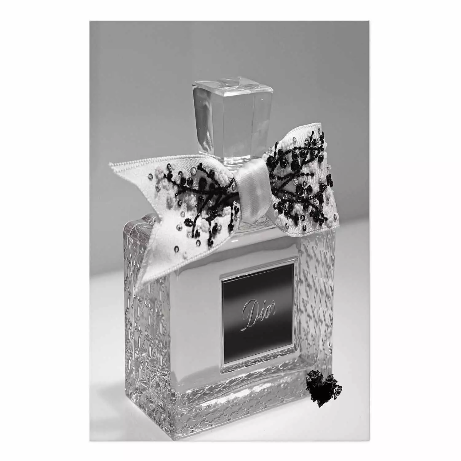 Black Dior luxury glass perfume bottle with ribbon on a white background