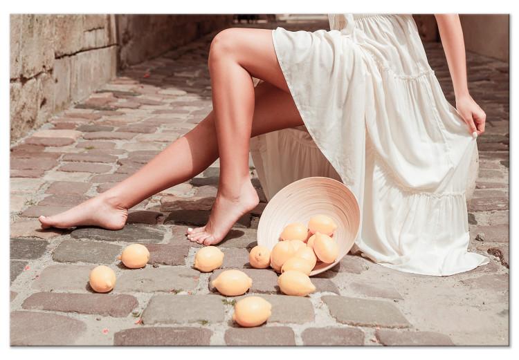 Canvas Print Lemons in the Sun (1-piece) - woman's legs and fruits lying on the street