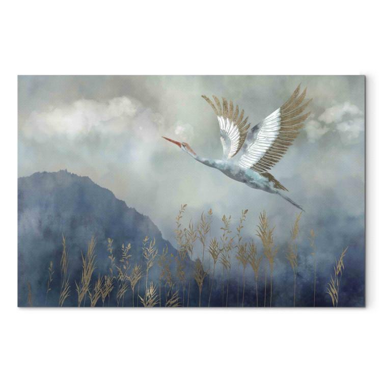 Canvas Print A Heron in Flight - A Bird Flying Against the Background of Dark Blue Mountains Covered With Fog