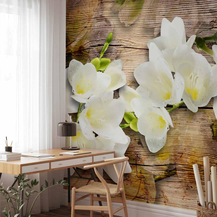 Wall Mural Beauty of Flowers - White freesia flower with shadow on a brown wooden background