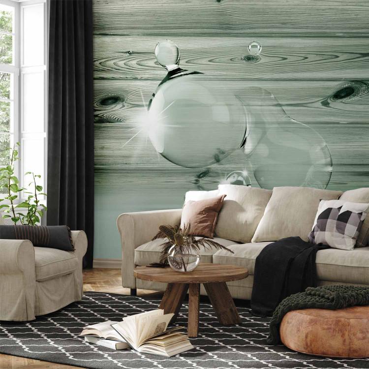 Wall Mural Spilled Water - water droplet with shimmer and design on gray wood