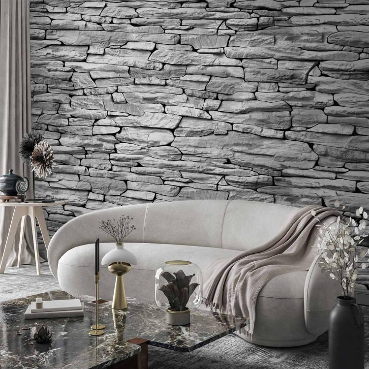 Wall Mural Grey grotto - light background with textured irregular stone blocks