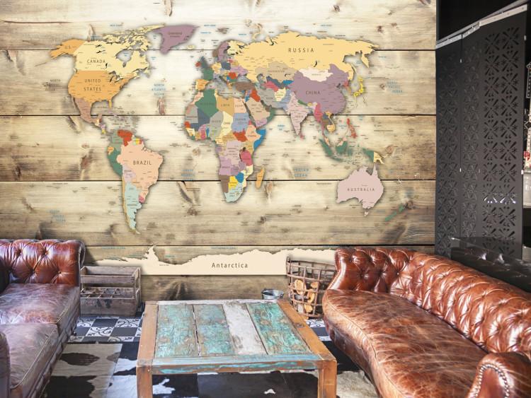 Wall Mural City states - a signed coloured world map on a background of wood planks