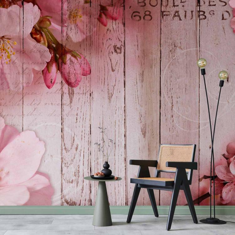 Wall Mural Apple blossoms - motif in shades of pink on a wood-textured background