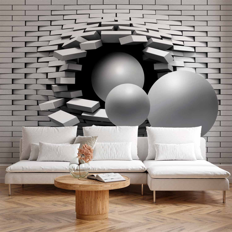 Photo Wallpaper Hole in the Wall - Broken white brick wall with a hole and gray spheres 61791