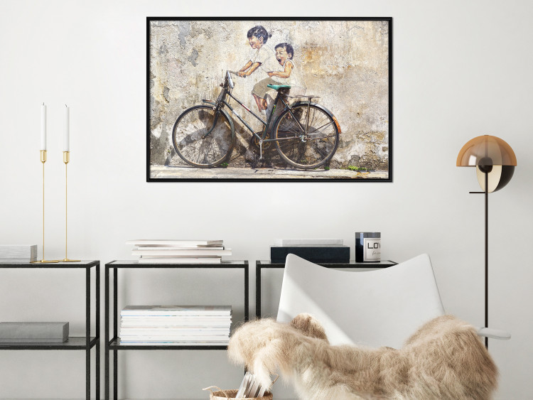 Wall Poster Carefree - retro black bicycle against a wall painted with children 130457 additionalImage 9