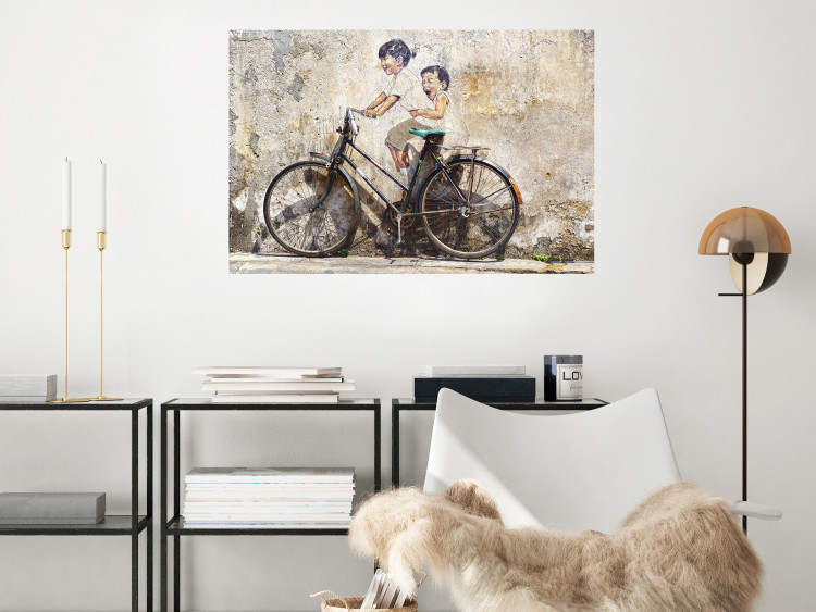 Wall Poster Carefree - retro black bicycle against a wall painted with children 130457 additionalImage 6