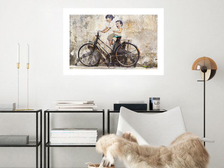 Wall Poster Carefree - retro black bicycle against a wall painted with children 130457 additionalImage 10