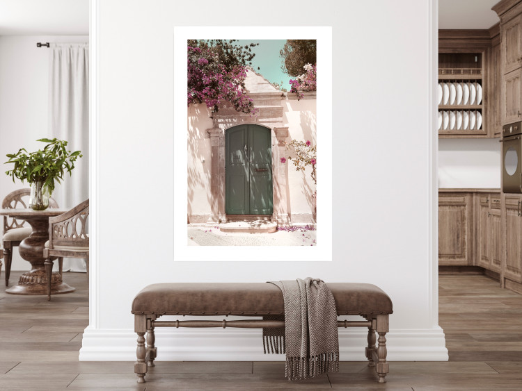 Poster Charming Alley - architecture of a wall with a green entrance in the sunlight 135757 additionalImage 13