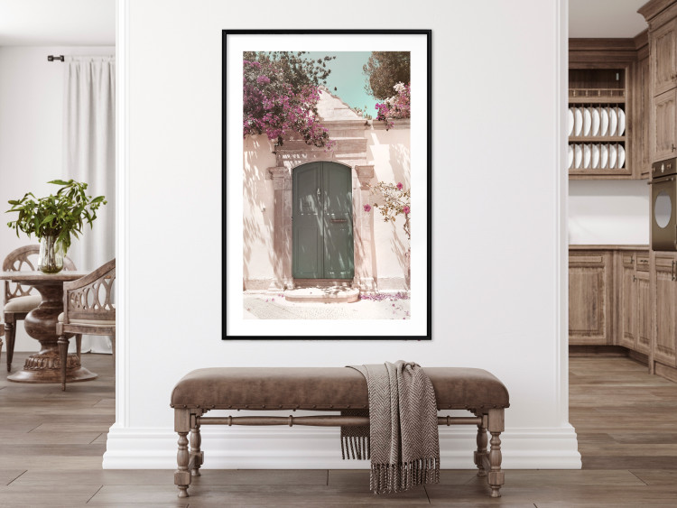 Poster Charming Alley - architecture of a wall with a green entrance in the sunlight 135757 additionalImage 12