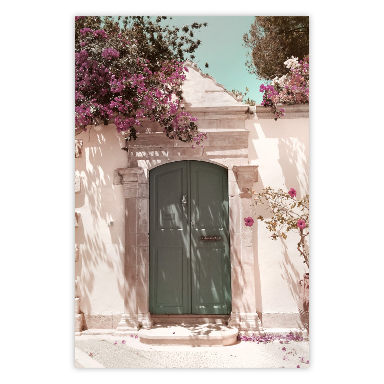 Poster Charming Alley - architecture of a wall with a green entrance in the sunlight 135757